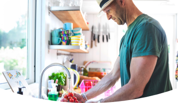 Hombre en la cocina lavando verduras